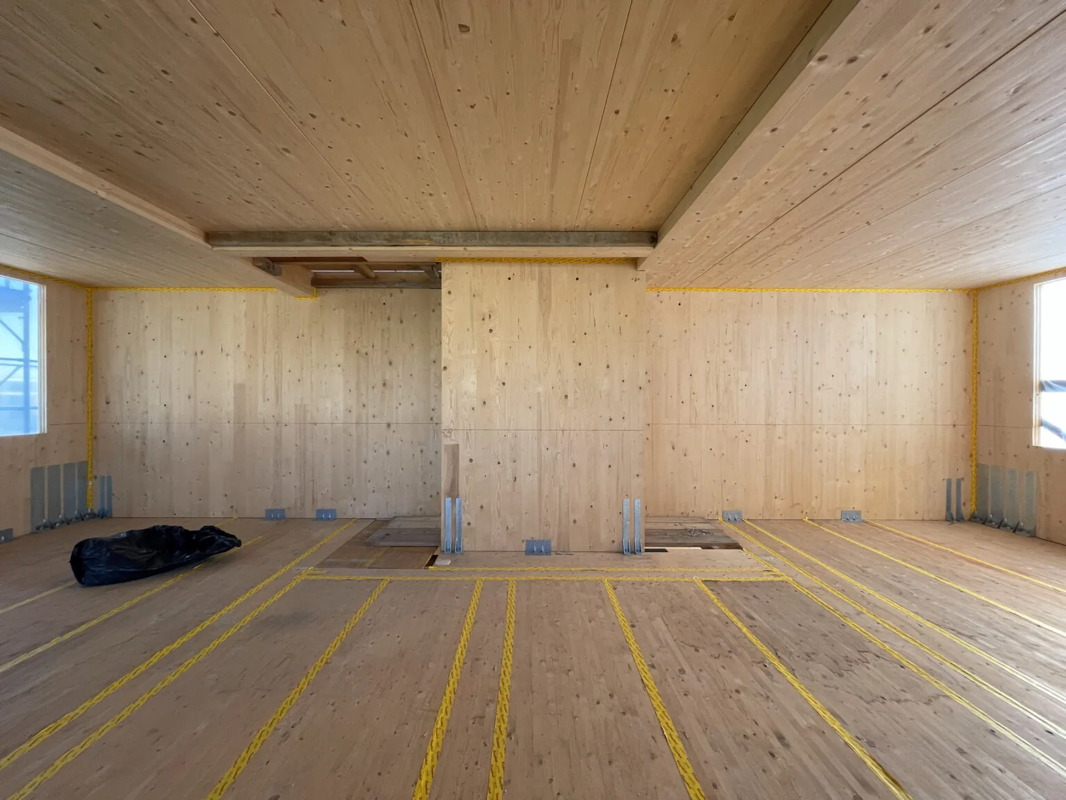 Interno di un edificio in X-Lam al grezzo: pareti e solaio in pannelli di legno massiccio a vista